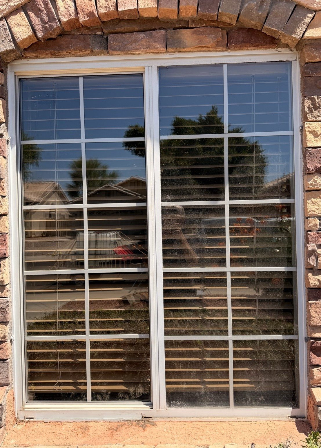 A window mid-cleaning: the left pane already crystal clear, the right pane still coated in dust — one photo, same light