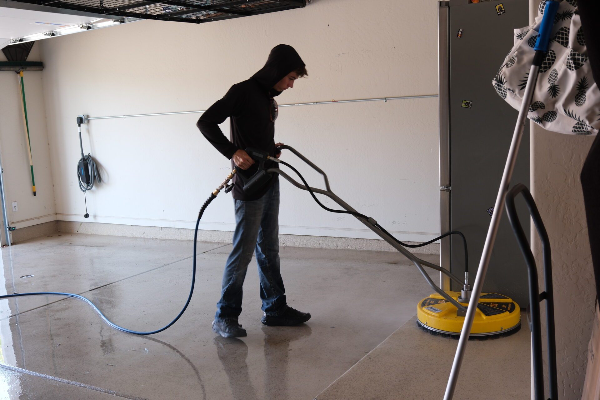 A REBEL crew member surface-cleaning a garage floor
