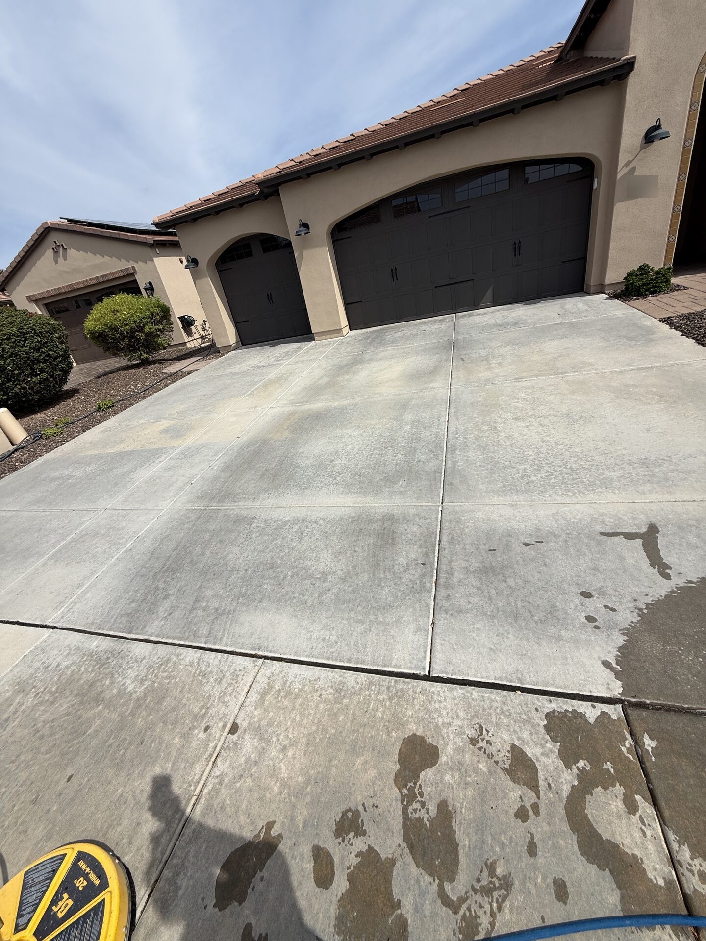 A Phoenix Valley driveway before any cleaning, the concrete darkened and blotchy with built-up dirt