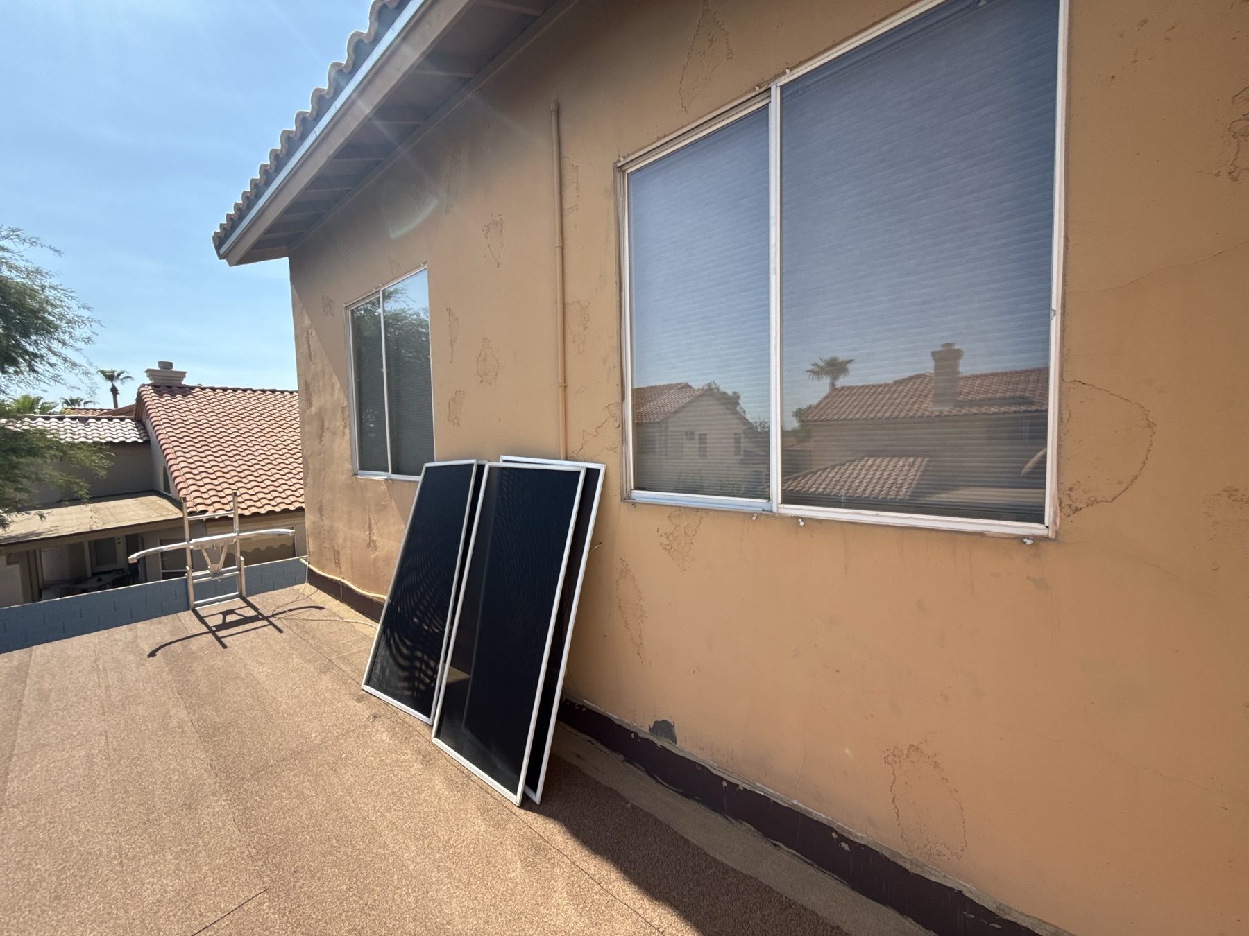 Windows with worn screens and new frames staged for install